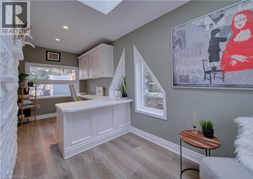Home office featuring a skylight, dark wood-style flooring, and an accent wall - 655 Ellengale Road, Burlington, ON - Indoor