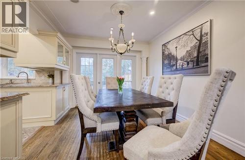 Dining space featuring a chandelier, ornamental molding, and light wood finished floors - 655 Ellengale Road, Burlington, ON - Indoor Photo Showing Dining Room