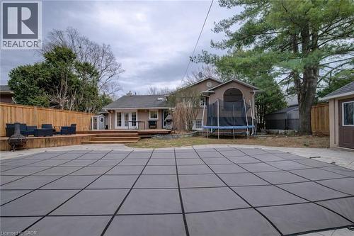 View of swimming pool with a fenced backyard, a trampoline, patio surround, a wooden deck, and french doors - 655 Ellengale Road, Burlington, ON - Outdoor With In Ground Pool