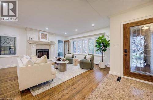 Living room with light wood-type flooring, ornamental molding, a glass covered fireplace, and recessed lighting - 655 Ellengale Road, Burlington, ON - Indoor Photo Showing Living Room With Fireplace