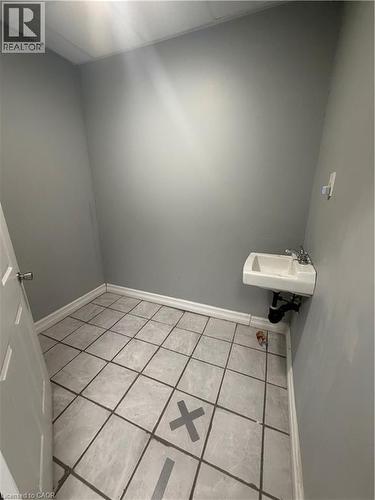 Bathroom featuring light tile patterned floors and a drop ceiling - 10 Sanford Avenue N, Hamilton, ON 