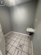 Bathroom featuring light tile patterned floors and a drop ceiling - 