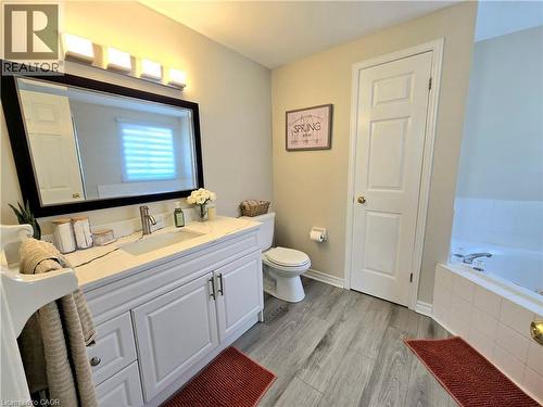 Bathroom featuring vanity, light wood-style flooring, and a garden tub - 59 Highgate Road Unit# 1, Kitchener, ON - Indoor Photo Showing Bathroom