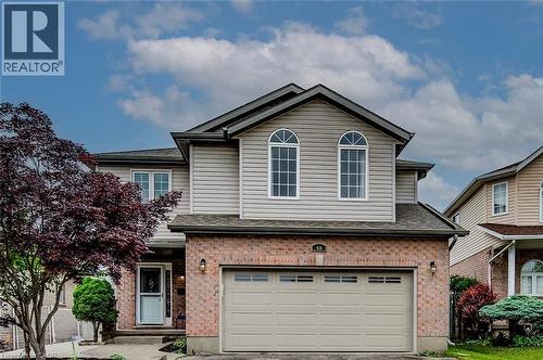 Traditional-style house featuring brick siding, a garage, and driveway - 59 Highgate Road Unit# 1, Kitchener, ON - Outdoor