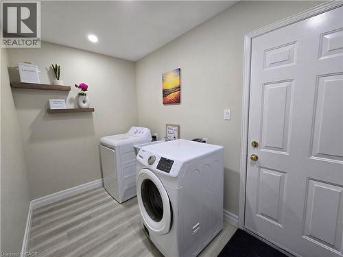 Laundry area with light wood-style flooring and independent washer and dryer - 59 Highgate Road Unit# 1, Kitchener, ON - Indoor Photo Showing Laundry Room