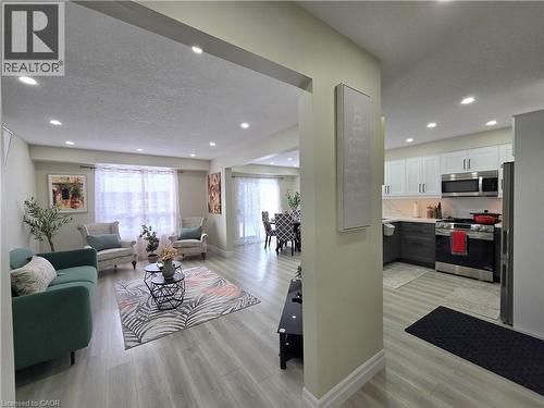 Living area featuring light wood finished floors, a textured ceiling, and recessed lighting - 59 Highgate Road Unit# 1, Kitchener, ON - Indoor