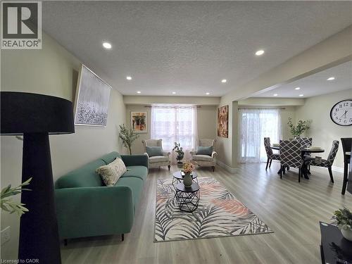 Living area featuring a textured ceiling, light wood-style flooring, and recessed lighting - 59 Highgate Road Unit# 1, Kitchener, ON - Indoor Photo Showing Living Room