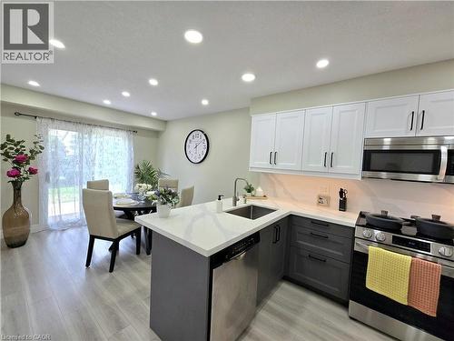 Kitchen featuring dual tone cabinetry, stainless steel appliances, a peninsula, light wood finished floors, and recessed lighting - 59 Highgate Road Unit# 1, Kitchener, ON - Indoor Photo Showing Kitchen