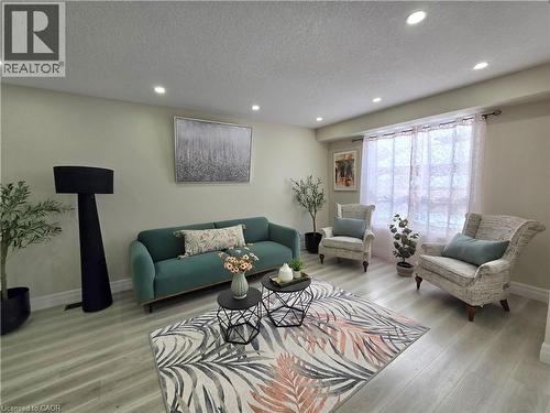 Living room with a textured ceiling, recessed lighting, and light wood finished floors - 59 Highgate Road Unit# 1, Kitchener, ON - Indoor Photo Showing Living Room