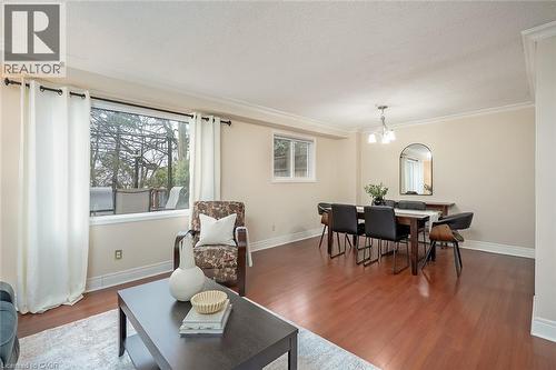 Dining room featuring wood finished floors, a textured ceiling, suspended lighting, and crown molding - 1278 Consort Crescent, Burlington, ON - Indoor