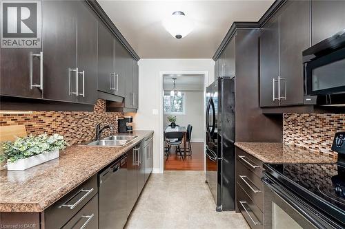 Kitchen with black appliances, backsplash, light tile patterned floors, and light stone countertops - 1278 Consort Crescent, Burlington, ON - Indoor Photo Showing Kitchen With Double Sink With Upgraded Kitchen