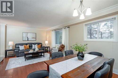 Dining room featuring wood finished floors, ornamental molding, a chandelier, and a textured ceiling - 1278 Consort Crescent, Burlington, ON - Indoor
