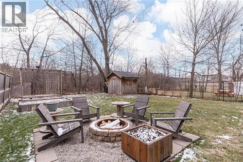 Fenced backyard with a storage unit, a fire pit, and a patio - 624 Burgess Avenue, Hamilton, ON - Outdoor