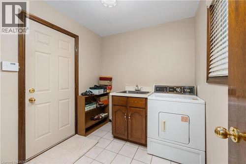 Laundry area featuring washer / clothes dryer, light tile patterned flooring, and cabinet space - 57 Derek Drive, Hamilton, ON - Indoor Photo Showing Laundry Room