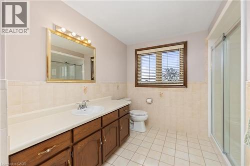 Bathroom with vanity, a stall shower, wainscoting, light tile patterned floors, and tile walls - 57 Derek Drive, Hamilton, ON - Indoor Photo Showing Bathroom