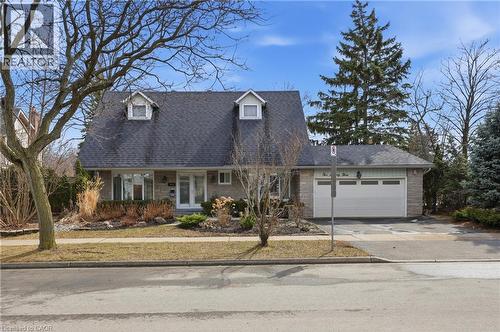 Cape cod house featuring a porch, a garage, driveway, brick siding, and roof with shingles - 273 Bryant Crescent, Burlington, ON - Outdoor With Facade