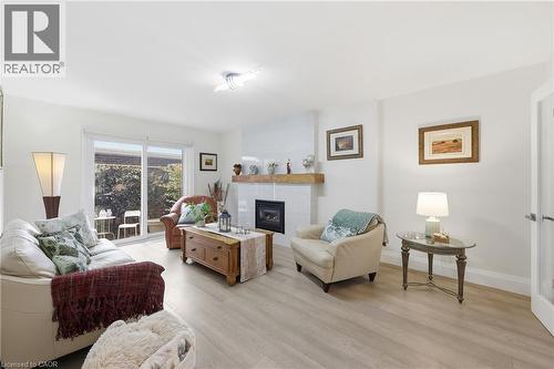 Living room featuring a glass covered fireplace and light wood finished floors - 273 Bryant Crescent, Burlington, ON - Indoor Photo Showing Living Room With Fireplace