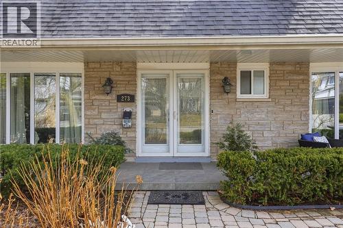 View of exterior entry featuring a porch, a shingled roof, and stone siding - 273 Bryant Crescent, Burlington, ON - Outdoor