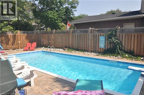 View of swimming pool with a fenced backyard, patio surround, and a diving board - 273 Bryant Crescent, Burlington, ON - Outdoor With In Ground Pool With Deck Patio Veranda With Backyard