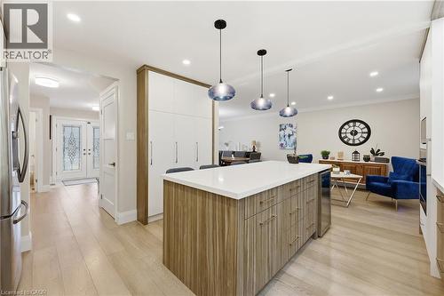 Kitchen with modern cabinets, a center island, light wood finished floors, decorative light fixtures, and stainless steel appliances - 273 Bryant Crescent, Burlington, ON - Indoor Photo Showing Kitchen With Upgraded Kitchen