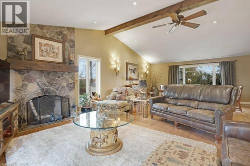 Living room with light wood-type flooring, a ceiling fan, and a fireplace - 5511 Second Line, Erin, ON - Indoor Photo Showing Living Room With Fireplace