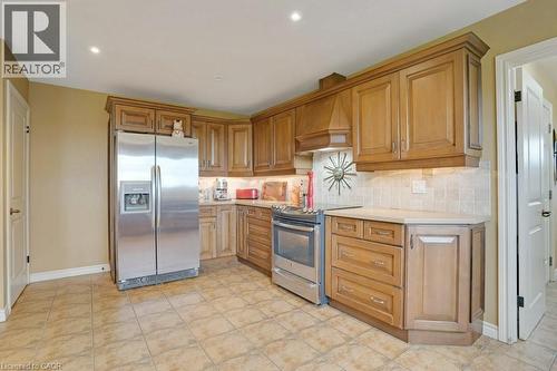 Kitchen featuring stainless steel appliances, wood finish cabinetry, decorative backsplash, recessed lighting, and light tile patterned floors - 5511 Second Line, Erin, ON - Indoor Photo Showing Kitchen