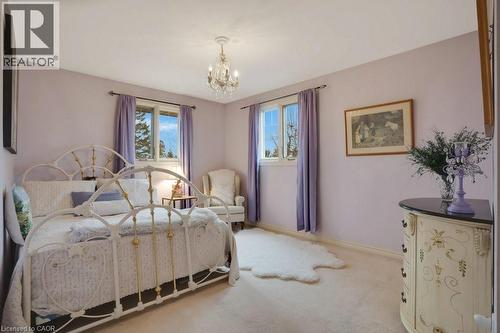 Carpeted bedroom with hanging lights and baseboards - 5511 Second Line, Erin, ON - Indoor Photo Showing Bedroom