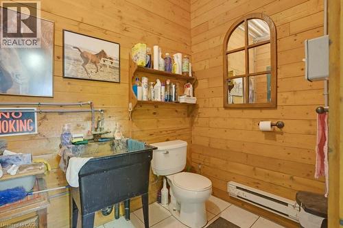 Half bathroom with wooden walls, tile patterned flooring, and a baseboard radiator - 5511 Second Line, Erin, ON - Indoor Photo Showing Bathroom