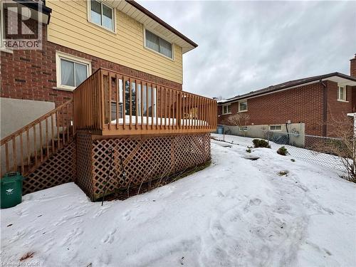Snow covered back of property featuring a wooden deck and brick siding - 86 Devonglen Drive, Kitchener, ON - Outdoor With Deck Patio Veranda With Exterior