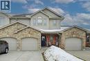 View of front facade featuring stone siding, covered porch, a garage, and driveway - 34 Harrison Street, Stratford, ON  - Outdoor With Facade 