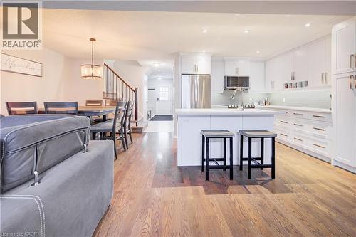 Kitchen featuring white cabinets, a breakfast bar, appliances with stainless steel finishes, hanging light fixtures, and recessed lighting - 34 Harrison Street, Stratford, ON - Indoor