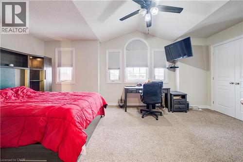 Carpeted bedroom featuring vaulted ceiling, ceiling fan, an office area, and a textured ceiling - 34 Harrison Street, Stratford, ON - Indoor Photo Showing Bedroom