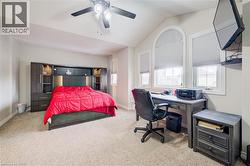 Bedroom with carpet floors, lofted ceiling, a ceiling fan, and an office area - 