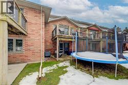 Back of house featuring a patio area, brick siding, a trampoline, and a balcony - 
