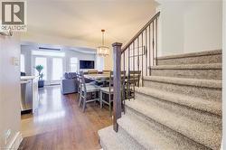 Dining room featuring dark wood-style floors, stairway, and a chandelier - 