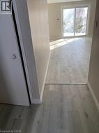 Hallway featuring light wood-type flooring and baseboards - 