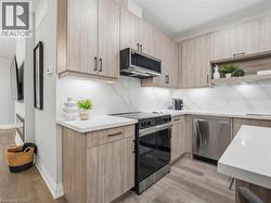 Kitchen with stainless steel appliances, light wood finished floors, open shelves, and modern cabinets - 