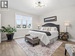 Bedroom featuring light wood-style flooring and a chandelier - 
