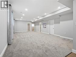 Below grade area with light carpet and recessed lighting - 