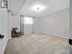 Living area featuring baseboards and light carpet - 