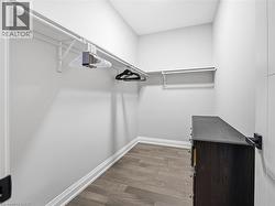 Walk in closet with dark wood-style flooring - 