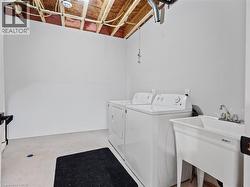 Laundry area featuring unfinished concrete flooring and independent washer and dryer - 