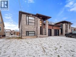 View of front of home featuring stone siding and a garage - 