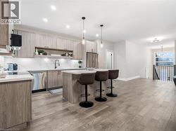 Kitchen featuring open shelves, a center island, a breakfast bar, and light wood-style floors - 