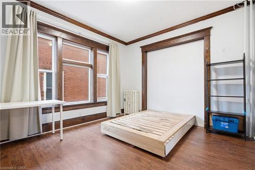 Bedroom featuring crown molding, dark wood finished floors, and radiator - 30 Regina Street N, Waterloo, ON - Indoor Photo Showing Bedroom