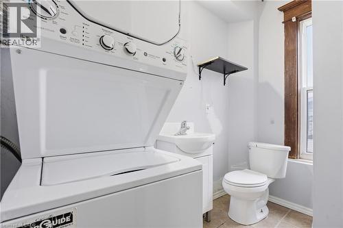 Full bath with vanity, stacked washer / dryer, light tile patterned floors, and shower / bathtub combination - 30 Regina Street N, Waterloo, ON - Indoor Photo Showing Laundry Room