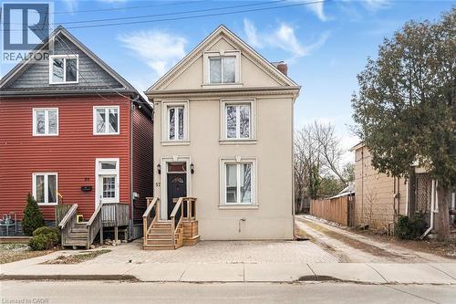 View of front facade featuring stucco siding and a chimney - 57 New Street, Hamilton, ON - Outdoor With Facade