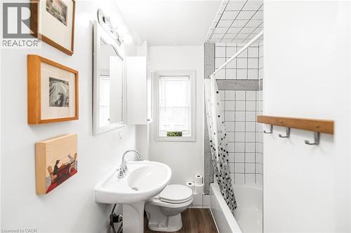 Full bath with shower / bath combo with shower curtain and dark wood-style floors - 57 New Street, Hamilton, ON - Indoor Photo Showing Bathroom
