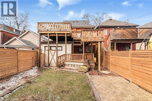 Rear view of house featuring a fenced backyard, a wooden deck, and roof with shingles - 57 New Street, Hamilton, ON - Outdoor With Deck Patio Veranda