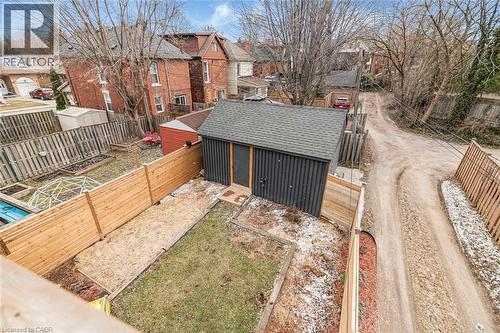 Fenced backyard featuring an outdoor structure and a residential view - 57 New Street, Hamilton, ON - Outdoor